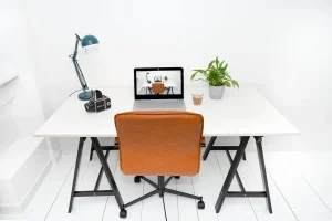 Ordentlich eingerichteter Arbeitsplatz mit Schreibtisch, Stuhl und Laptop