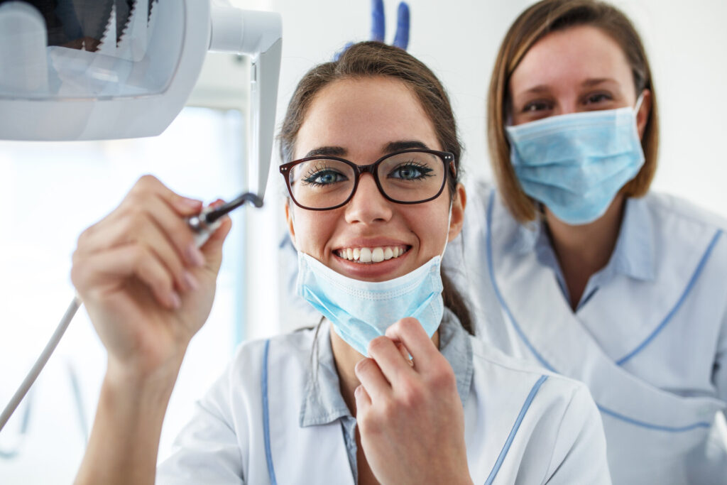 Zwei weibliche Zahnärzte in einer Zahnarztpraxis untersuchen die Zähne eines Patienten