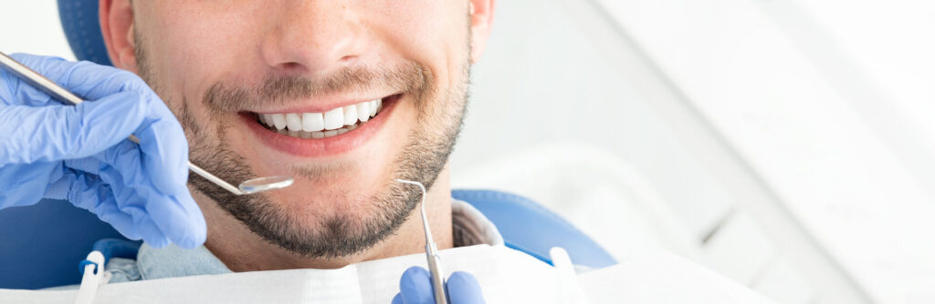 Junger Mann beim Zahnarzt. Zahnpflege, Pflege der Zähne