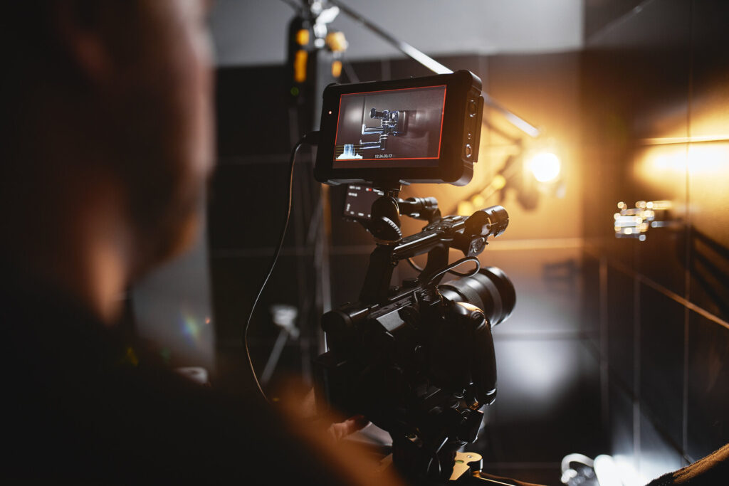 Hinter den Kulissen bei der Erstellung von Videoinhalten, filmt ein professionelles Team von Kameraleuten mit einem Regisseur Werbespots.